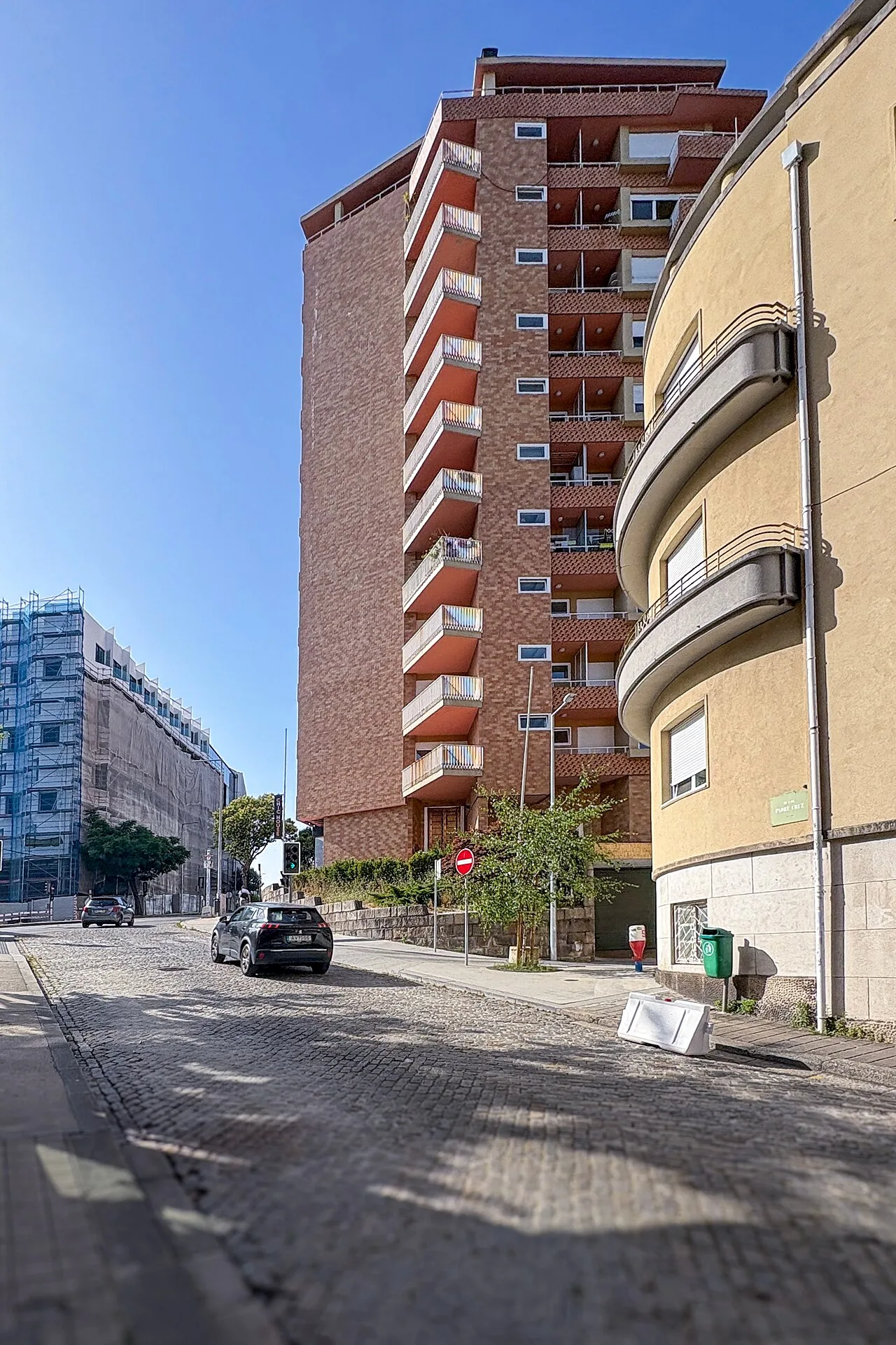 Edifício de tijolo e varandas geométricas no Porto